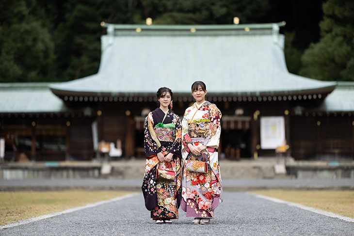 神社で振袖を着て並ぶ2人の若い女性