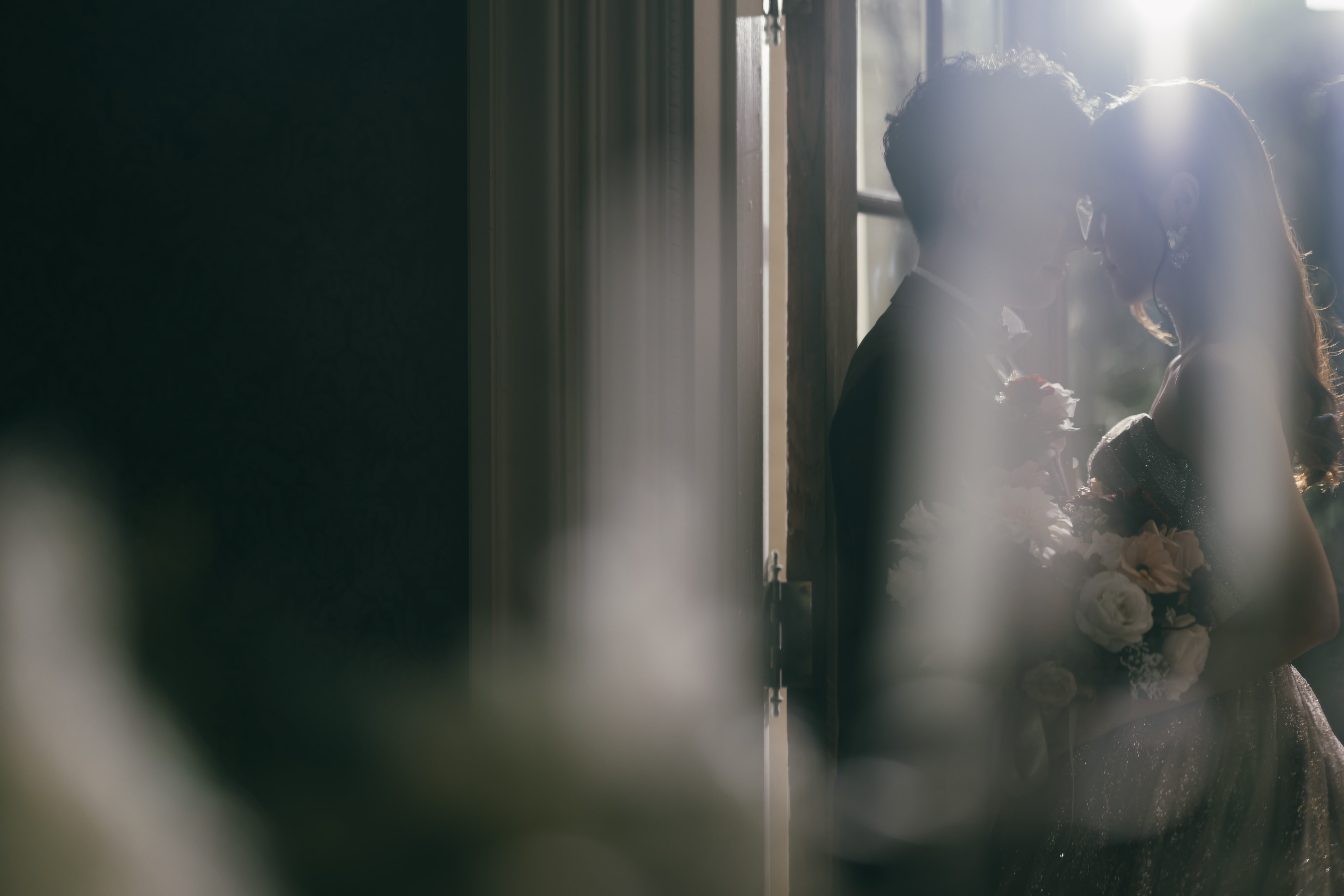 結婚式場でおでこをつけ寄り添う新郎新婦のウェディングフォト